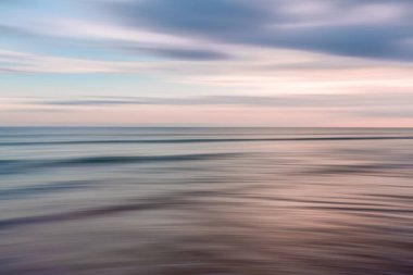 Gökyüzü ve denizin kusursuz bir harmanında ufuk boyunca uzanan ruhani renkler.