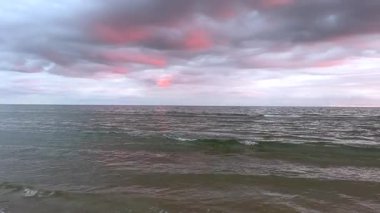 Rüya gibi bir günbatımı gökyüzünün altında yumuşak dalgalar. Yüksek kalite 4k görüntü