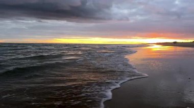 Gün batımı renkleri ıslak kuma yansıyor. Yüksek kalite 4k görüntü