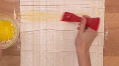 Phyllo hamur ve eritilmiş tereyağı yakın plan ahşap kaplama, pişirme işlemi. Yüksek kalite 4k görüntü