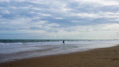 Solo balıkçı sakin bir balık avı için sörf yapmaya cesaret eder. Yüksek kalite 4k görüntü