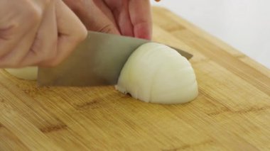 Pişirme hazırlığı için beyaz soğanı ince ince dilimliyorum. Yüksek kalite 4k görüntü
