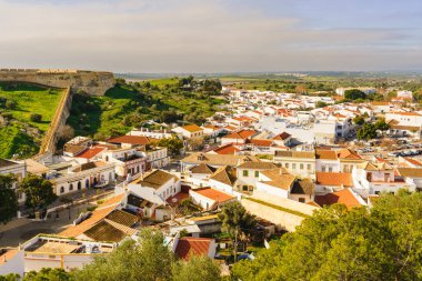 Parlak renkli evler ve dolambaçlı sokaklar eski kalenin yanındaki manzaralı Castro Marim kasabasını dolduruyor..