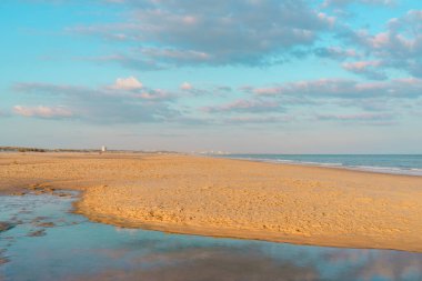 Gelgit havuzu, sakin bir sahildeki renkli gökyüzünü yansıtır..