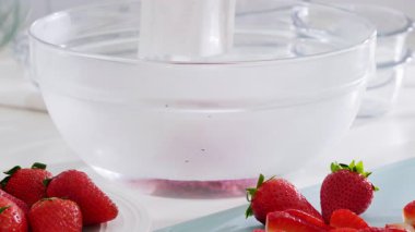 Çilekli jöle hazırlamak için jelatin karışımı çırpıyorum. Yüksek kalite 4k görüntü