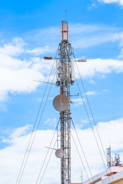 Gökyüzü altında antenleri ve tabakları olan iletişim kulesi.