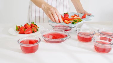 Cam kaselere taze kesilmiş çilek ve sıvı jöle ekliyorum..