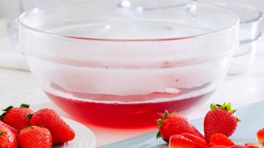 Tezgahta taze karışık çilek jölesiyle dolu cam kase..