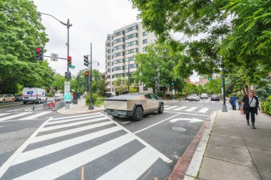 Washington D.C., ABD - 21 Mayıs 2025. Paslanmaz çelik kamyon Washington D.C. yaya geçidinden yaya ve trafik ışıklarıyla geçiyor..