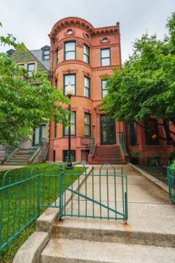 Washington D.C., ABD - 21 Mayıs 2025. Klasik kırmızı tuğlalı ev. Detaylı mimari aksanları ve önünde kapısı olan bir ev..