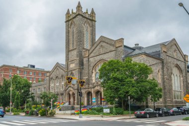 Washington D.C., ABD - 21 Mayıs 2025. Girişlerinde uzun kemerli pencereler ve gurur bayrakları olan büyük taş kilise..