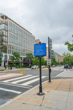 Washington D.C., ABD - 21 Mayıs 2025. Şehrin kavşağında mavi bir tabela ve çizgili binalar var..