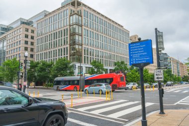 Washington D.C., ABD - 21 Mayıs 2025. Arabalar, otobüsler ve yüksek cam binalarla dolu bir kavşak..