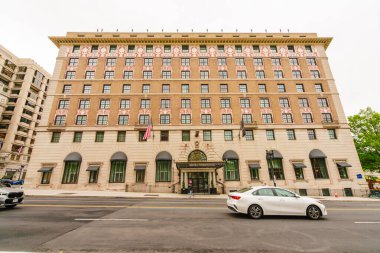 Washington D.C., ABD - 21 Mayıs 2025. Simetrik pencere tasarımı ve Amerikan bayrağıyla süslü bir otelin ön görüntüsü..