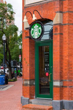 Washington D.C., ABD - 22 Mayıs 2025. Klasik Starbucks mağazası hareketli bir caddedeki büyüleyici kırmızı tuğladan bir binada..