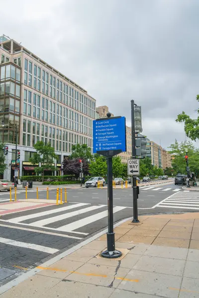 Washington D.C., ABD - 21 Mayıs 2025. Şehrin kavşağında mavi bir tabela ve çizgili binalar var..