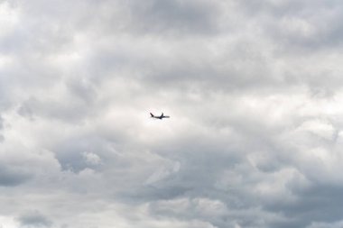 Washington D.C., ABD, 23 Mayıs 2025, Yolcu uçağı bulutlu ve karamsar bir gökyüzünde uçuyor..