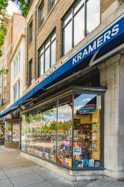 Washington D.C., ABD - 23 Mayıs 2025 - Renkli gökkuşağı kalpleri ve bayraklarla dekore edilmiş Kramers kitapevi penceresi, camdaki binaların görüntüsü ve yansımaları düzgünce düzenlenmiş kitaplar.