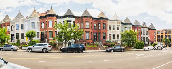 Washington D.C., ABD, 24 Mayıs 2025. Taretleri ve pencereleri olan renkli tarihi evler Adams Morgan mahallesinde güneşli bir caddede.