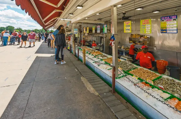 Washington D.C., ABD - 24 Mayıs 2025. Maine Avenue Balık Pazarı 'nda canlı yengeç satan işçiler arasında dostça bir sohbet..