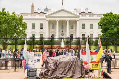 Washington D.C., ABD, 25 Mayıs 2025. İşaret ve bayraklı protestocular Beyaz Saray 'ın önünde siyah demir bir çitin arkasında toplandılar..