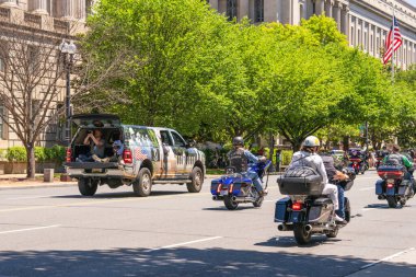 Washington D.C., ABD, 25 Mayıs 2025. Anma Günü 'nde Constitution Bulvarı' nda bir konvoy dolusu motosikletli yolcuyu filme alan vatansever temalı bir kamyon..