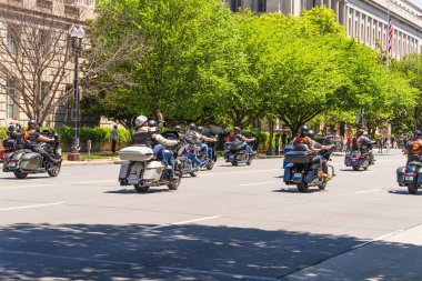 Washington D.C., ABD, 25 Mayıs 2025. Anma töreninde motosiklet sürücüleri ağaçlarla kaplı bir caddede yürürken seyircilere el sallıyor..