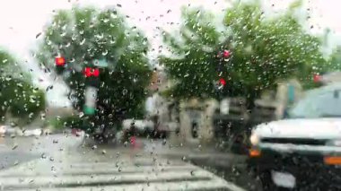 Yağmurlu bir günde yağmurla kaplı bir pencereden araçların bulanık görüntüsü. Yüksek kalite 4k görüntü