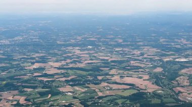 Banliyödeki evler ve yollar, uzak bir kasaba merkezine doğru uzanan yoğun yeşil ormanların arasına dağılmış durumda. Yüksek kalite 4k görüntü