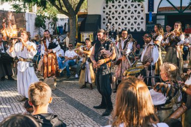 Castro Marim, Portekiz, 29 Ağustos 2025. Ortaçağ kıyafetleri içindeki halk müzik grubu fuarda coşkulu bir kalabalık için çalıyor.