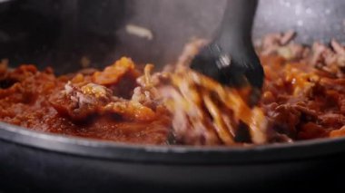 Hot ground beef cooking with tomato sauce being mixed in a frying pan. High quality 4k footage