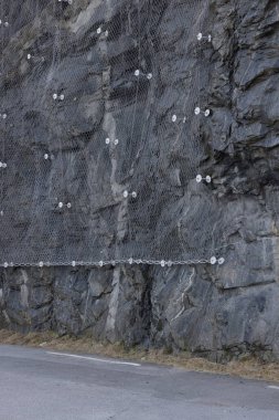 Kayanın derinliklerine demirlenmiş çelik ağla kayalık duvarı güçlendiriyorum. Düşen kayalar yola düşmez. Çelik çivili fındıklı.