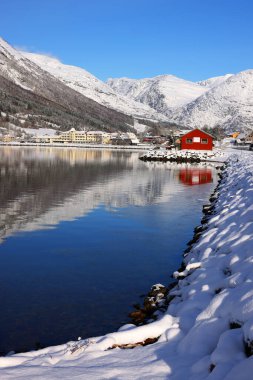 Norveç 'in Vestland ilçesi Sunnfjord Belediyesi' ndeki Skei köyü ve Jolstravatnet Gölü manzarası. Kışın manzaralı, sudaki yansımalarla..