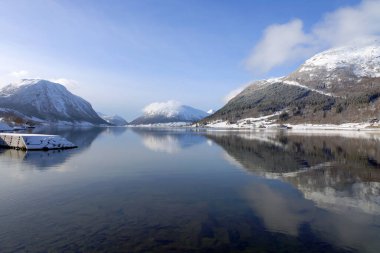 Norveç 'in Vestland ilçesi Sunnfjord Belediyesi' ndeki Skei köyü ve Jolstravatnet Gölü manzarası. Kışın manzaralı, sudaki yansımalarla..