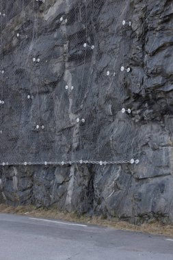 Kayanın derinliklerine demirlenmiş çelik ağla kayalık duvarı güçlendiriyorum. Düşen kayalar yola düşmez. Çelik çivili fındıklı.