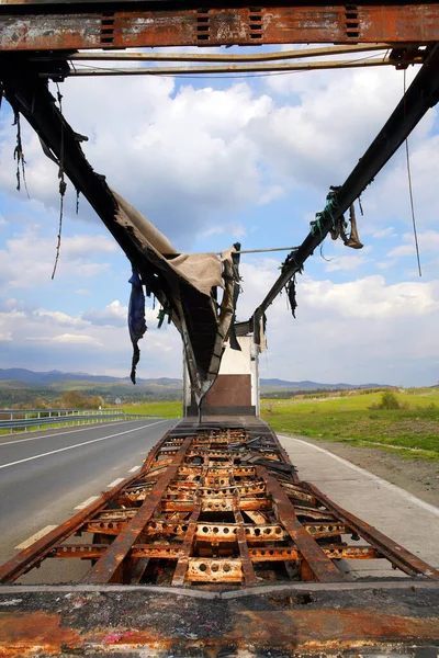 道路の側面に燃え尽きたトラックのイメージ バン全体が焼失し 貨物は失われた 貨物輸送のリスク 雲のある青空 — ストック写真