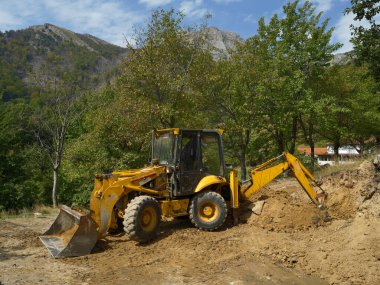 Güçlü ön teker yükleyicisi ya da inşaat alanında çalışan buldozer. İnşaattaki toprak işleri. Toprak işleri için güçlü modern ekipman