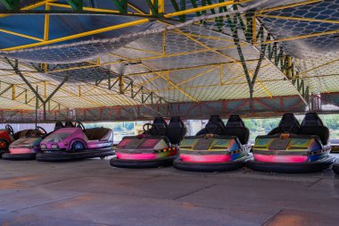 Terk edilmiş renkli çarpışan arabalar, lunaparkta yarış arabaları, tümseklerle yarış