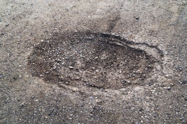 Yol yüzeyinin kötü durumu. Bahar mevsimi. Asfaltdelik, araba ile hareket riski, kötü asfalt, tehlikeli yol, asfalt çukurlar
