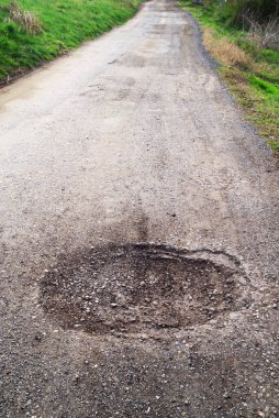 Yol yüzeyinin kötü durumu. Bahar mevsimi. Asfaltdelik, araba ile hareket riski, kötü asfalt, tehlikeli yol, asfalt çukurlar