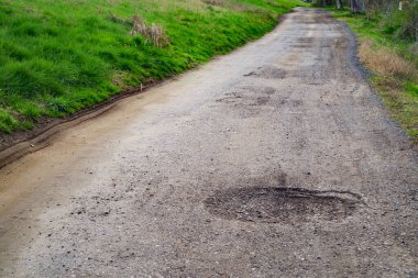 Yol yüzeyinin kötü durumu. Bahar mevsimi. Asfaltdelik, araba ile hareket riski, kötü asfalt, tehlikeli yol, asfalt çukurlar