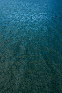 Gölün yüzeyindeki parlak ve yansıtıcı su. Bir gölün ya da küçük dalgalı deniz suyunun soyut arkaplanı. Su dokusu