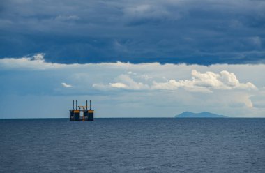 Thyrrenian Denizi 'nde fırtınalı bulutların altında petrol platformu