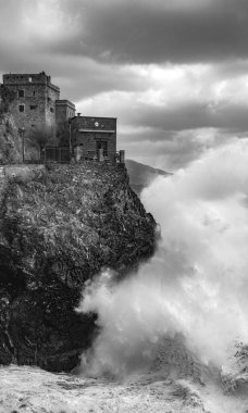 Monterosso al Mare, Cinque Terre, İtalya yakınlarındaki fırtınalı bir kış gününde Ligurian denizindeki uçurumdan dalgalar düşüyor.