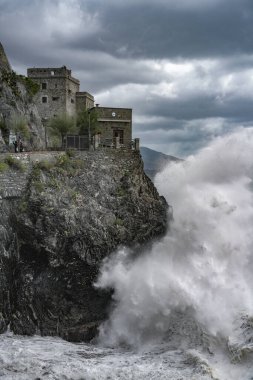Monterosso al Mare, Cinque Terre, İtalya yakınlarındaki fırtınalı bir kış gününde Ligurian denizindeki uçurumdan dalgalar düşüyor.