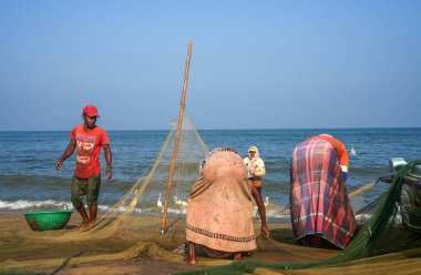 Negombo sahilinde balıkçı tekneleri ve balıkçılar. Negombo, Sri Lanka 'nın batı kıyısında büyük bir şehirdir..
