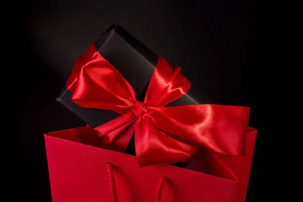 情人节快乐或黑色星期五购物概念与黑色礼品盒和红色缎子在黑色背景下鞠躬 带有复制空间的宣传标语 — 图库照片