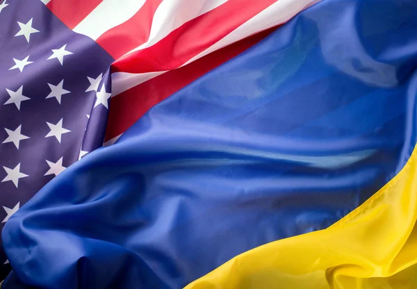 United States of America and Ukrainian flags together on one picture. Ukraine and US Partnership during war of 2022 concept background.