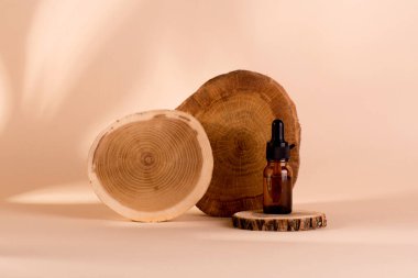 Çavdar gevreğinin organik yağı ve şişedeki buğday damlası bej arka plana karşı ahşap bir podyumda duruyor..