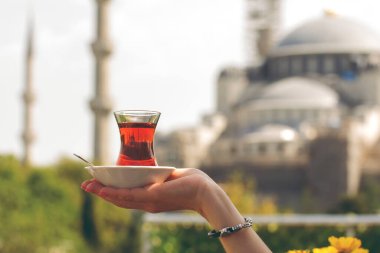 Türkiye 'nin İstanbul kentindeki Sultanahmet Camii' nin arka planında bir bardak Türk çayı.